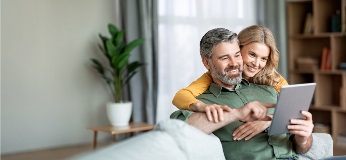 Couple sur un canapé en train de regarder une tablette