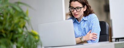 Eine Person, die konzentriert an einem Laptop arbeitet.